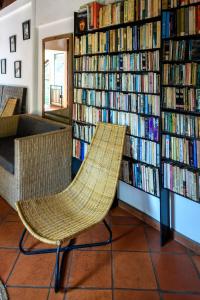 a library with a rattan chair in front of bookshelves at Sala Baï Hotel & Restaurant School in Siem Reap