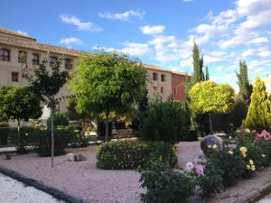 un giardino con fiori e alberi di fronte a un edificio di Nuestra Señora del Carmen a Caravaca de la Cruz