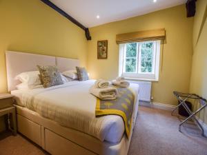 a bedroom with a bed with towels on it at Archers in Winchcombe