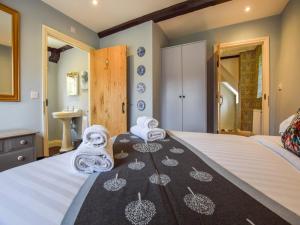 a bedroom with a bed with towels on it at Archers in Winchcombe