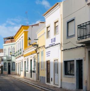 a row of buildings on a city street at Baixa de Faro Rooftop in Faro