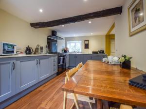 a kitchen with a wooden table and a dining room at Archers in Winchcombe