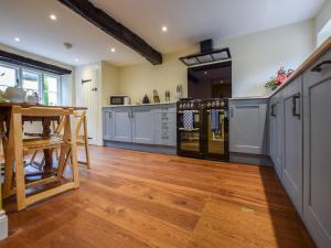 a large kitchen with wooden floors and a wooden table at Archers in Winchcombe