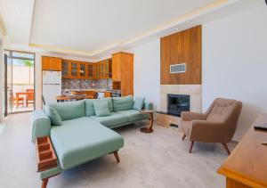 ein Wohnzimmer mit einer grünen Couch und einer Küche in der Unterkunft Villa 2 Sleeps 4 Isolated Honeymoon-Villa Sardunya in Kaş