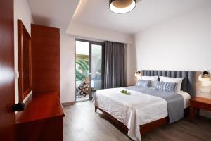 a bedroom with a bed and a sliding glass door at Anna's House in Georgioupolis