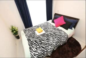 1 dormitorio con 1 cama con estampado de cebra y 2 almohadas en Kamiya TK Building 202 en Tokio