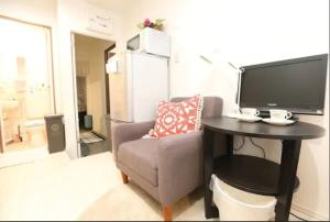 a living room with a tv and a chair and a table at Kamiya TK Building 202 in Tokyo
