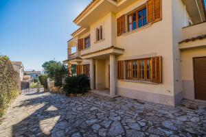 ein Haus mit einer Kopfsteinpflasterstraße davor in der Unterkunft Vistamar 5A - Puerto de Alcudia in Alcúdia