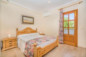 Schlafzimmer mit einem Bett, einem Fenster und einer Tür in der Unterkunft Vistamar 5A - Puerto de Alcudia in Alcúdia