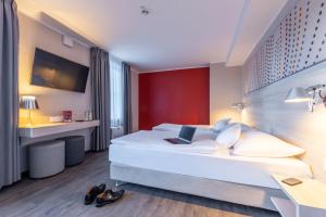 a hotel room with a bed with a laptop on it at Serways Hotel Reinhardshain Nord in Grünberg