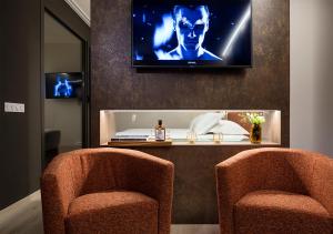 a living room filled with furniture and a tv at Axel Hotel San Sebastián - Adults Only in San Sebastián