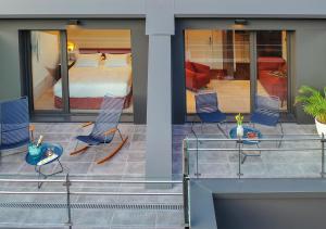 a room with two chairs and a bed in a room at Axel Hotel San Sebastián - Adults Only in Donostia-San Sebastián