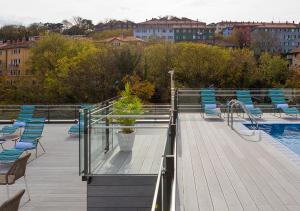 a deck with chairs and a pool with a bunch of buildings at Axel Hotel San Sebastián - Adults Only in Donostia-San Sebastián