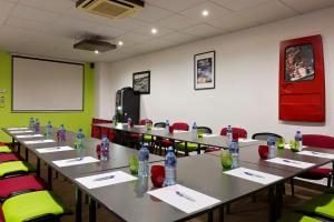 a conference room with tables and chairs with water bottles at Enzo Hotels Reims Tinqueux by Kyriad Direct in Reims