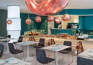 a restaurant with tables and chairs and a large red orb at Axel Hotel San Sebastián - Adults Only in Donostia-San Sebastián