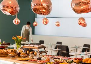 a table with many plates of food and lights at Axel Hotel San Sebastián - Adults Only in Donostia-San Sebastián