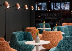 a group of chairs and a table with flowers on it at Axel Hotel San Sebastián - Adults Only in Donostia-San Sebastián