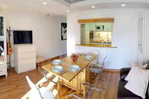 a living room with a wooden table with chairs at Apto. luminoso-6PAX-WIFI-15'/tren Plaza Catalunya in Sant Adria de Besos