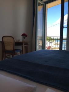 a bedroom with a large blue bed and a window at Hotel Televrin in Nerezine
