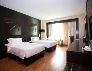 a hotel room with two beds and a television at Vouk Hotel Suites, Penang in George Town