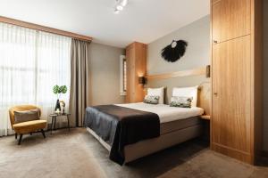 a hotel room with a bed and a chair at The Delphi - Amsterdam Townhouse in Amsterdam