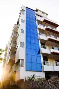 un grand bâtiment avec des fenêtres en verre bleu dans l'établissement Hotel Park Riviera, à Guwahati