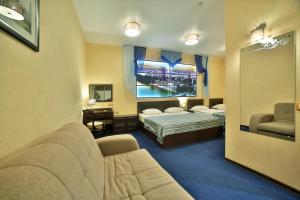 ペンザにあるHELIOPARK Cruiseのソファ、ベッド、鏡が備わる客室です。