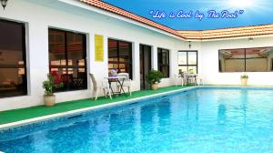 a swimming pool in front of a house at Tropicana Hotel in Manama