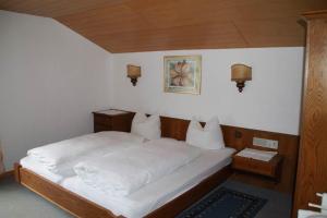 a bedroom with a bed with white blankets and pillows at Gästehaus Andrea in Schruns-Tschagguns