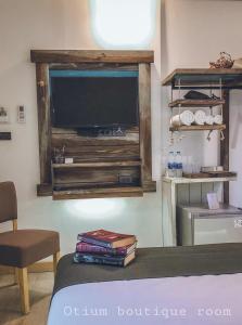 a bedroom with a large television in a wall at Otium Boutique Room in Pai