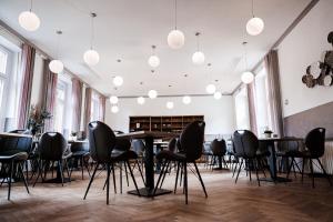 Großes Zimmer mit Tischen, Stühlen und Beleuchtung in der Unterkunft Gasthof-Hotel Biedendieck in Warendorf