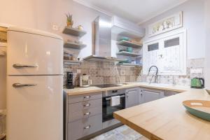 uma cozinha com um frigorífico e uma bancada de madeira em Stylish, comfy apartment by Konnect, Corfu city center em Corfu Town