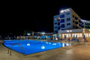 a large swimming pool in front of a hotel at night at TETYK Hotel in Protaras