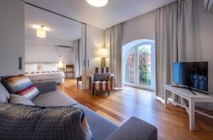 a living room filled with furniture and a tv at My Suite Lisbon Guest House – Principe Real in Lisbon