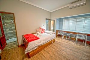 1 dormitorio con 1 cama, mesa y sillas en Crisp Guest Rooms, en Bloemfontein