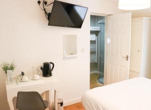 a room with a bed and a television on the wall at The Queen's Head Hotel in Buxton
