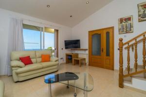 uma sala de estar com um sofá e uma mesa de vidro em Villa Los Robles em Begur