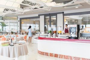 restauracja z dwoma osobami stojącymi przy ladzie w obiekcie Hotel Cambridge w mieście Lido di Jesolo