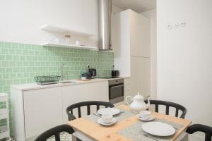 uma cozinha com uma mesa de madeira com cadeiras e uma cozinha em Montebelo Lisbon Downtown Apartments em Lisboa