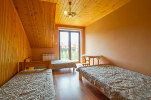um quarto com duas camas e uma janela em Pod Świerkami - pokoje em Kacwin