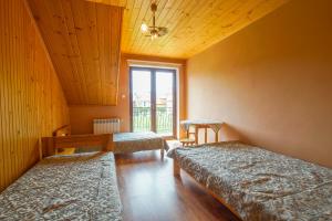 a room with two beds and a window at Pod Świerkami - pokoje in Kacwin