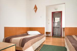 een slaapkamer met 2 bedden en een badkamer bij Hotel Beta in Cluj-Napoca