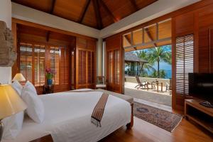 a bedroom with a white bed and a television in it at Villa Praison in Layan Beach