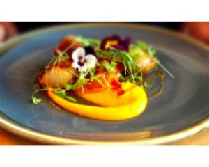 a blue plate with food on a table at Seabreeze Restaurant With Rooms in Aberdyfi