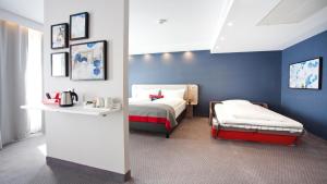 a hotel room with two beds and a table at Holiday Inn Express - Saarbrücken by IHG in Saarbrücken