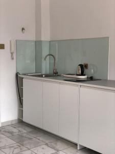 eine Küche mit weißen Schränken und einer Spüle in der Unterkunft APARTAMENT 6 Rynek in Breslau + 3 Fotos