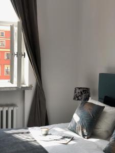 Schlafzimmer mit einem Bett mit einem Fenster und einem Kissen in der Unterkunft APARTAMENT 6 Rynek in Breslau