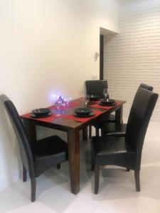 una mesa de madera con sillas negras y un ordenador portátil. en Apartament Centrum Zakopane, en Zakopane