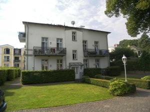 una casa blanca con césped delante en Villa Baroni BF nur 200m vom Ostseestrand entfernt en Bansin