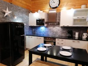 cocina con mesa y reloj en la pared en Hippu Apartment, en Ruka